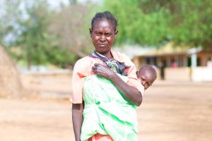 Former leishmaniasis patient standing with her child