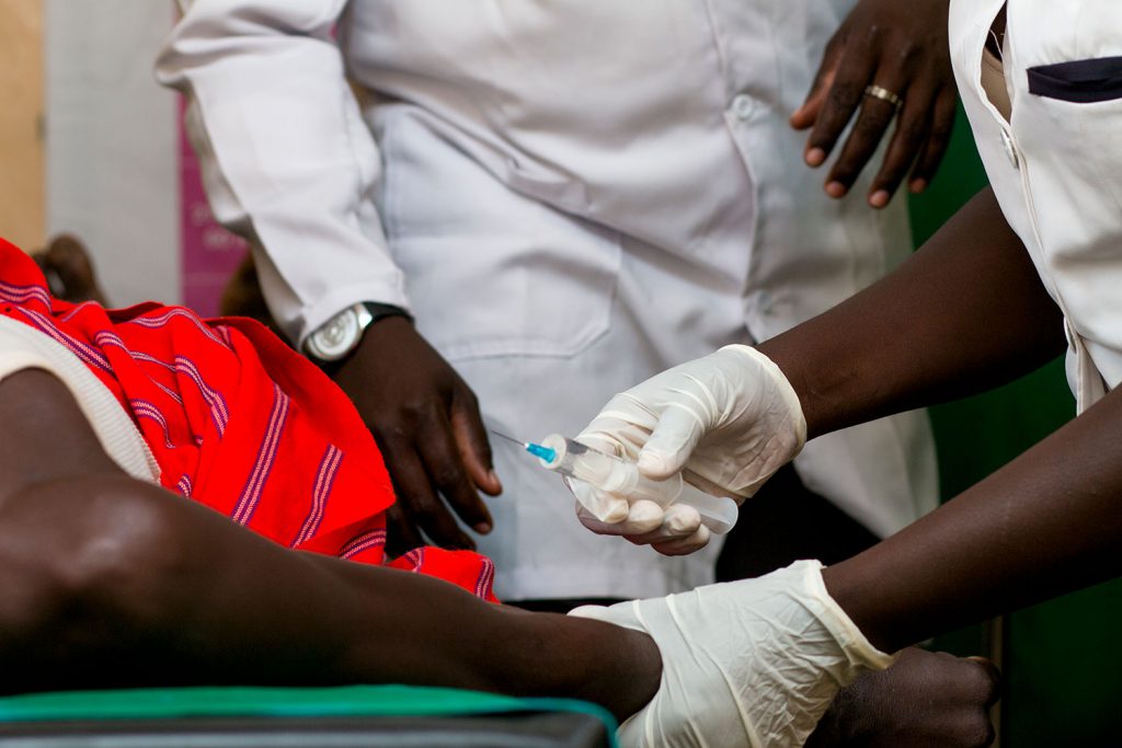 Docteurs treating a patient with a needle