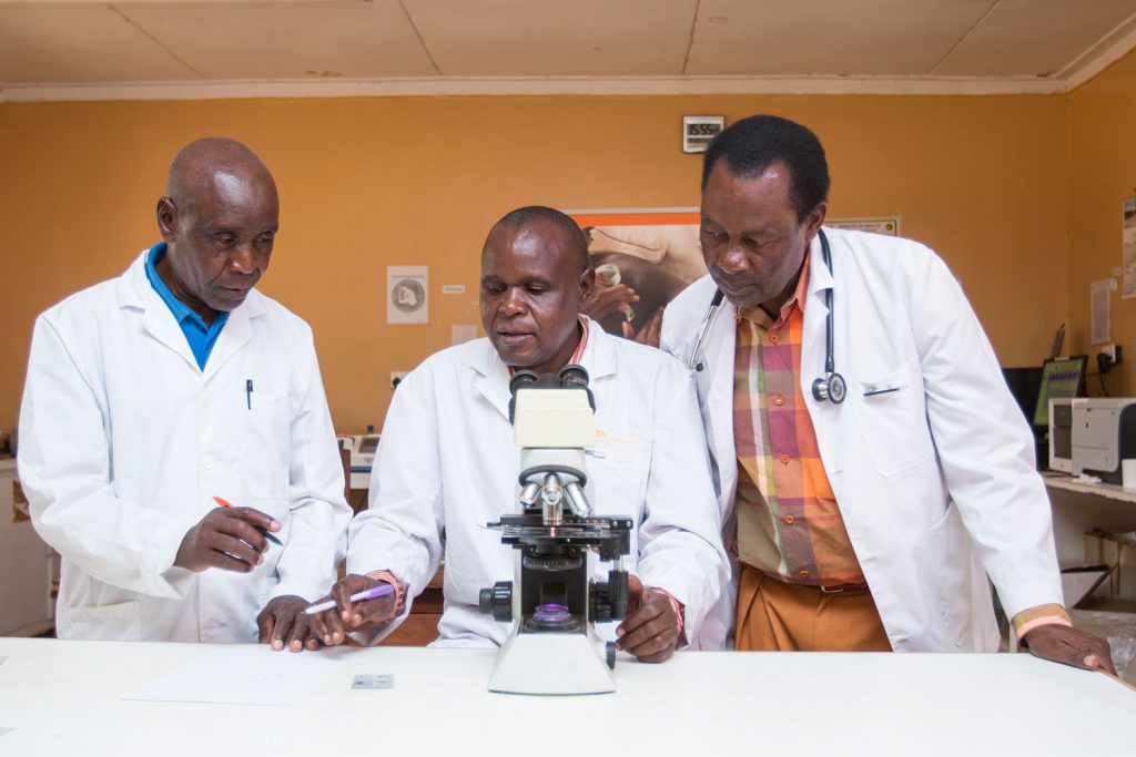 Docteurs discussing in front of a microscope